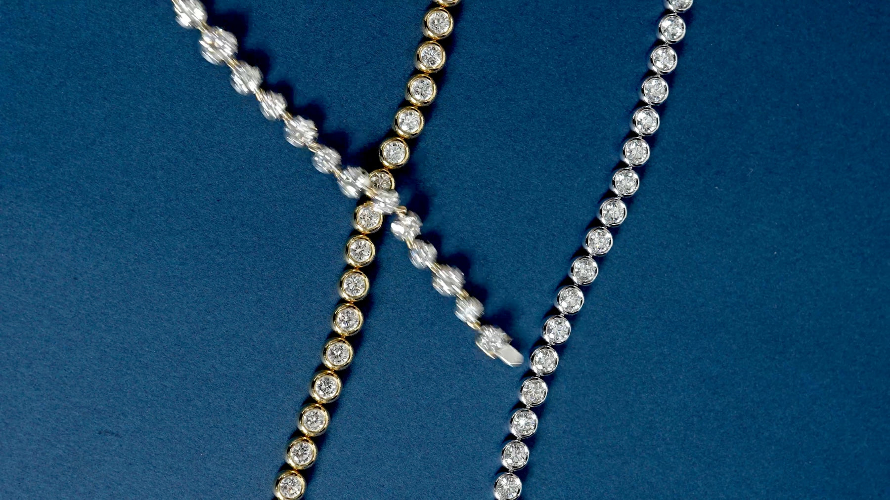 Diamond jewelry moving across a deep blue surface